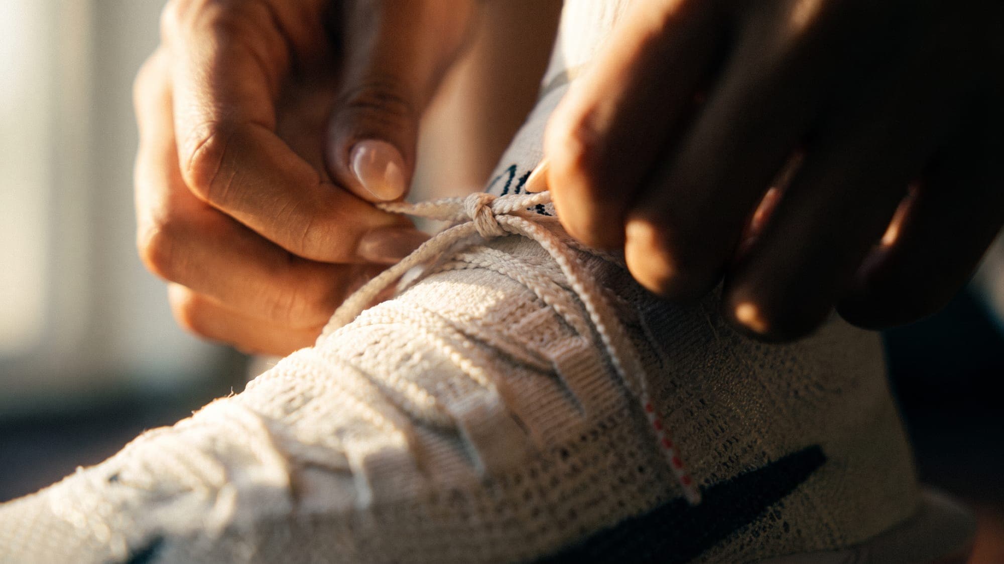 How to stop skipping workouts: fingers tightening a shoelace, ready before the morning.